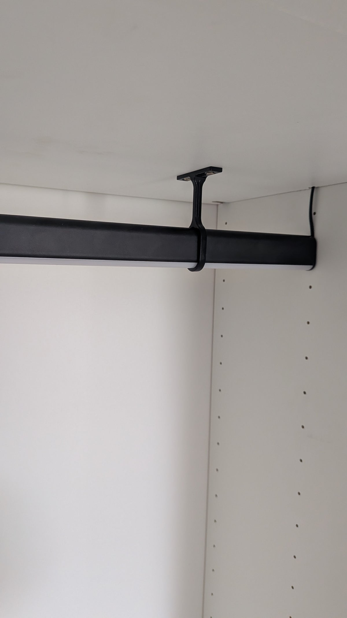 Premium LED clothes rail light giving a boutique-style glow inside a fitted wardrobe