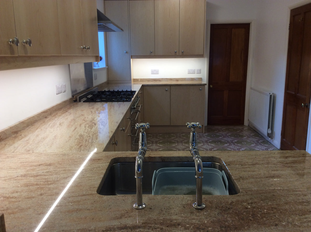 Under-cabinet LED lights switched on above a kitchen counter at night